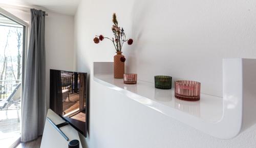 a living room with a white shelf and a mirror at Ferienwohnung Vergissmeinnicht in Ostseebad Sellin