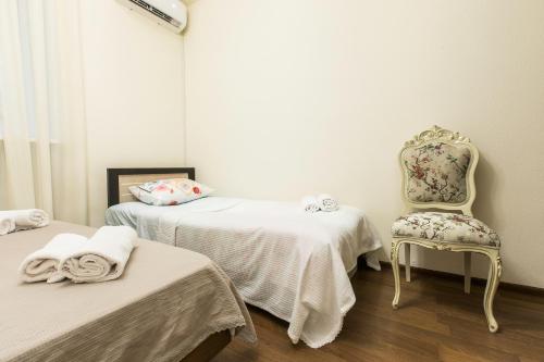 a room with two beds and a chair at Sweet Home 8 VIP at Freedom Square in Tbilisi City