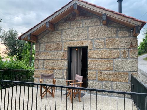 a stone house with two chairs in front of it at Casa AURORA in Amarante