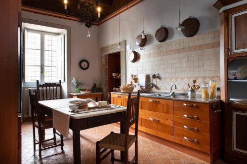 a kitchen with a table and chairs and a sink at Il Castello di San Michele in San Michele in Teverina