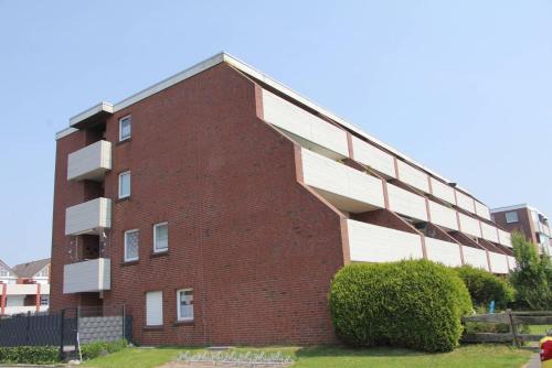 a brick building with balconies on the side of it at Ferienwohnung Utkiek in Dornumersiel