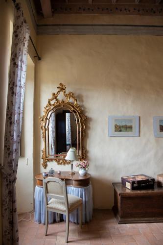 a room with a table with a mirror and a chair at Il Castello di San Michele in San Michele in Teverina