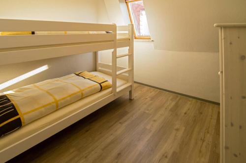 ドルヌマージールにあるFerienwohnung Franziskaのウッドフロアの小さな客室で、二段ベッドが備わります。