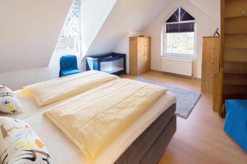 ドルヌマージールにあるFerienhaus Inselrosenのベッドルーム1室(ベッド2台、青い椅子付)