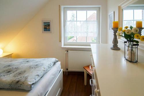 a bedroom with a bed and a table with flowers at Ferienhaus Strandruhe in Dornumersiel