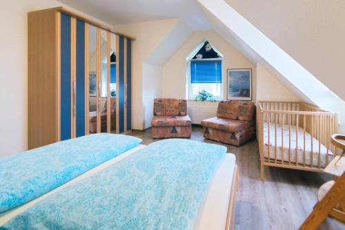 ein Schlafzimmer mit 2 Betten und eine Treppe mit Treppenaufgang in der Unterkunft Ferienhaus Sieleck in Dornumersiel