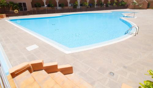 una grande piscina con pavimento piastrellato di MEDANO4YOU The Loft 007 a El Médano