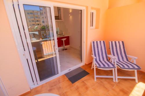 due sedie blu e bianche in una stanza con balcone di MEDANO4YOU The Loft 007 a El Médano
