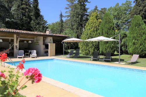 - une piscine avec des chaises et des parasols à côté d'une maison dans l'établissement Domaine de Pouroutounat, à Mirepoix