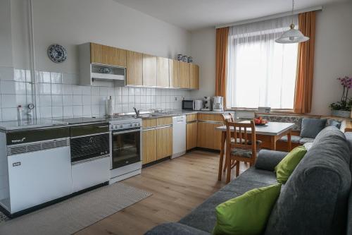kuchnia i salon z kanapą i stołem w obiekcie Vorstadt-Appartement Haus Monika w mieście Äußere Ragnitz