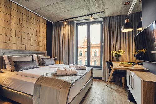 um quarto com uma cama, uma secretária e uma janela em The Bridge Suites em Cracóvia