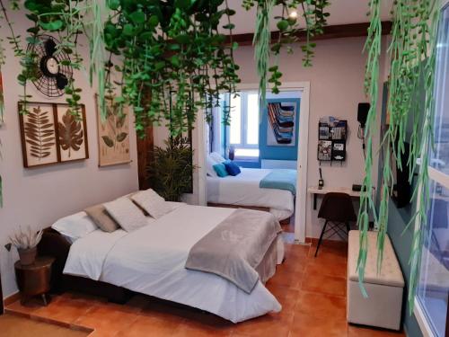 a bedroom with two beds and potted plants at River Side Olabeaga by homebilbao in Bilbao