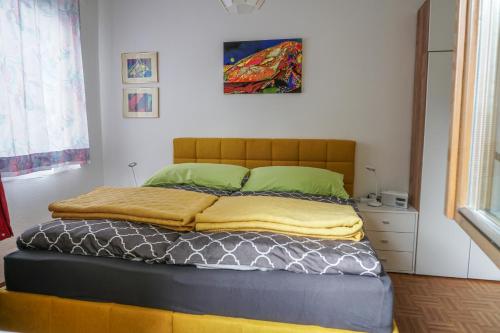 sypialnia z dużym łóżkiem z zielonymi poduszkami w obiekcie Vorstadt-Appartement Haus Monika w mieście Äußere Ragnitz