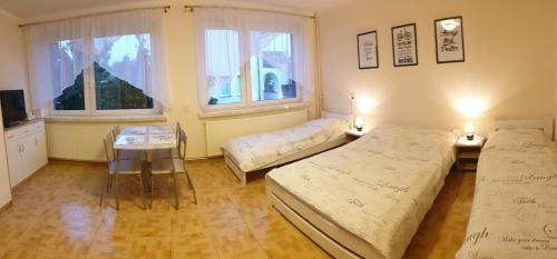 a bedroom with two beds and a table and a window at Emides in Pobierowo