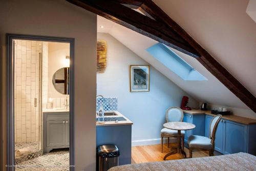 a attic kitchen with blue cabinets and a blue ceiling at La Petite Folie in Honfleur