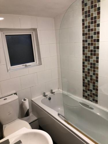 een badkamer met een toilet, een bad en een wastafel bij Rj s house in Merthyr Tydfil