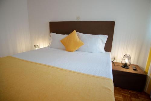 a bedroom with a large bed with two yellow pillows at Gerês Guest House in Geres