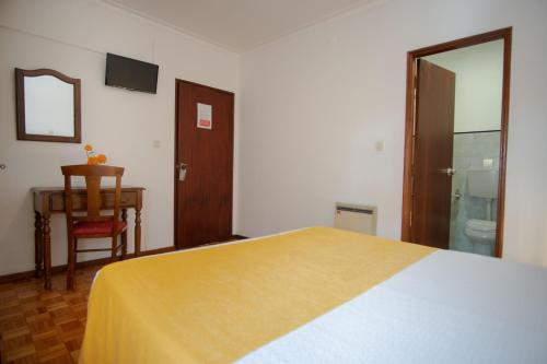 a bedroom with a bed and a table and a desk at Gerês Guest House in Geres