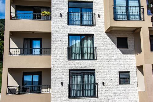 an apartment building with windows and balconies at Ralux apartman Tivat in Tivat