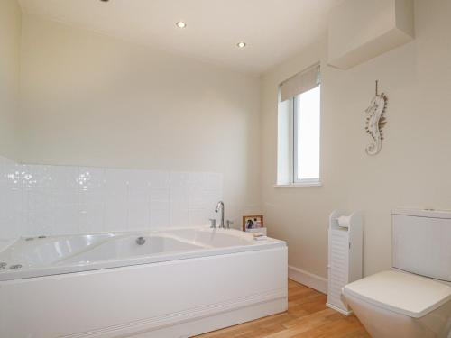 Hebridean View في Trumpan: حمام أبيض مع حوض ومرحاض