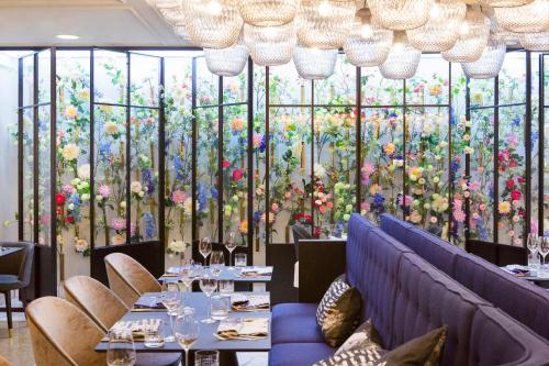 a restaurant with a large wall of flowers at The Fritz Düsseldorf Königsallee in Düsseldorf