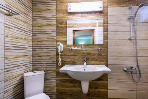 uma casa de banho com um lavatório, um WC e um espelho. em Hotel Dafi em Plovdiv