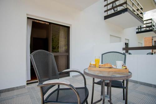a table and chairs with a tray of food on a patio at Gerês Guest House in Geres