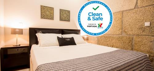 a bed with a sign that says clean and safe at Bugalha My Loft Douro 2 in Peso da Régua