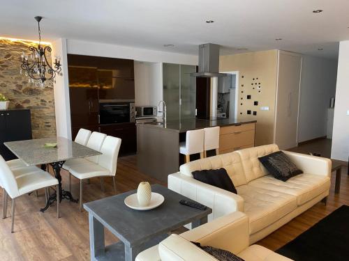 a living room and kitchen with a couch and a table at Apartamento céntrico y moderno in Ferrol