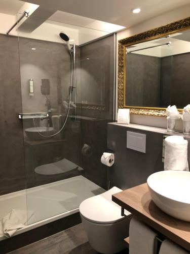a bathroom with a shower and a toilet and a sink at Hotel Restaurant Der Engel, Sasbachwalden in Sasbachwalden