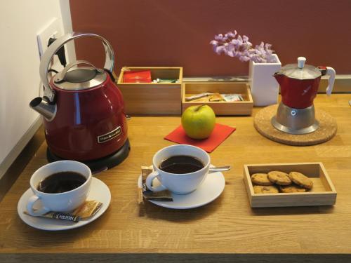 two cups of coffee and cookies on a table at Foresteria Conti, sulle tracce di Shakespeare in Padova