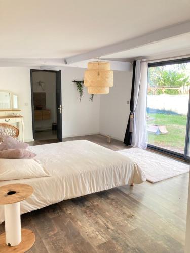 a bedroom with a large bed and a large window at Villa Nymphea in Saint-Pierre-dʼAutils
