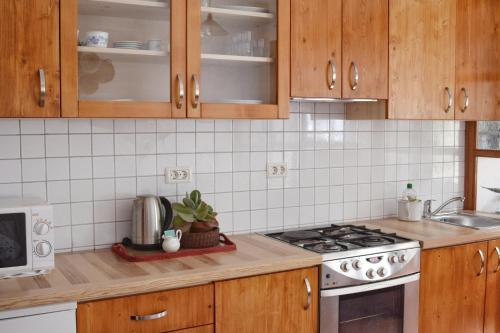 a kitchen with wooden cabinets and a stove top oven at Apartma Raft, Bovec in Bovec