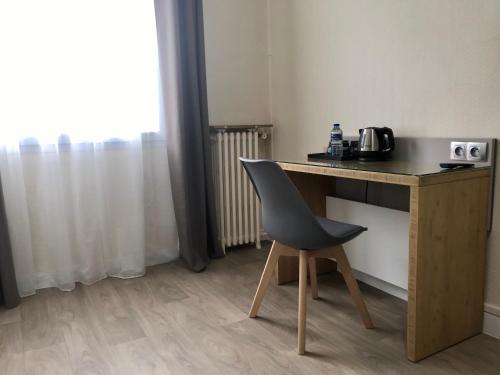 a desk with a chair in a room at Residence Hoche in Le Pré-Saint-Gervais