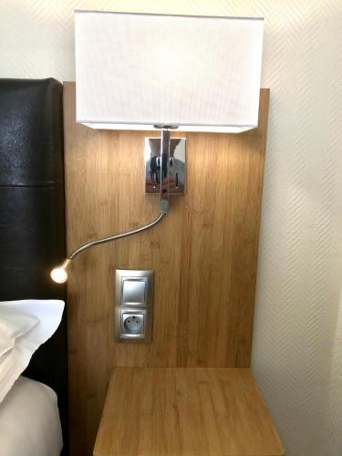 a lamp on a wall next to a bed at Residence Hoche in Le Pré-Saint-Gervais