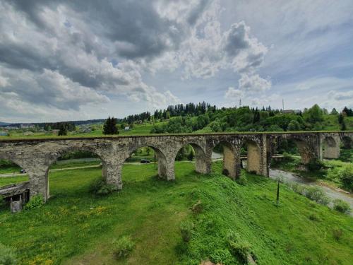 an old stone bridge over a green field at Lucy in Yaremche