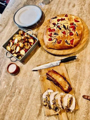 a table with a pizza and a knife and a pan of corn at The Tower House B&B in Thomastown