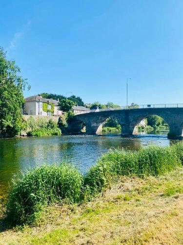a bridge over a river with grass in the foreground at The Tower House B&B in Thomastown