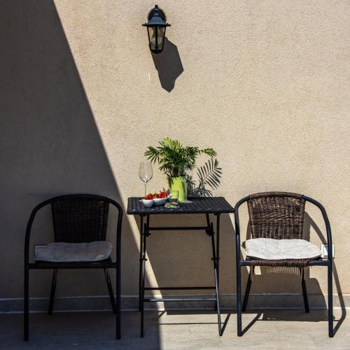 two chairs and a table with a plant and a lamp at Ralux apartman Tivat in Tivat