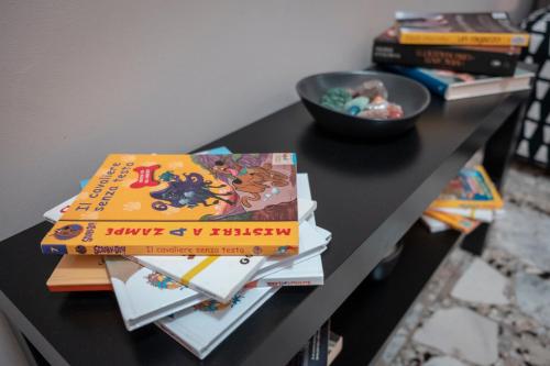 a table with a pile of books on it at Civico 8 B&B - Appartamento in Parma