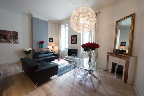 a living room with a black couch and a glass table at Design Smart Flat Bordeaux in Bordeaux