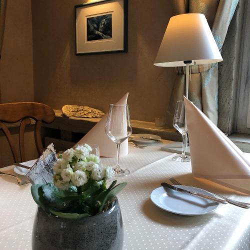 a table with a vase of flowers and a laptop at Hotel Restaurant Der Engel, Sasbachwalden in Sasbachwalden