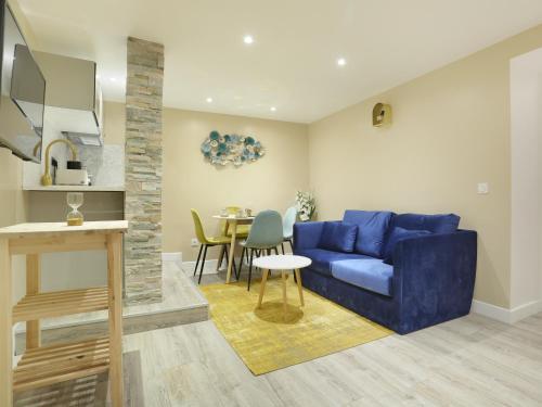 un salon avec un canapé bleu et une table dans l'établissement Rent a Room - Apartment St Honore, à Paris