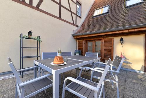 une table et des chaises devant une maison dans l'établissement Appartement La Grande Terrasse du Centre, à Colmar