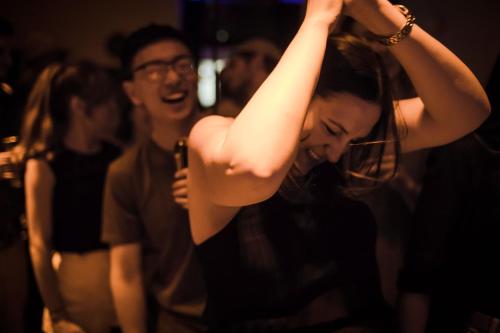 a woman with her arm in the air at a party at Astor Hyde Park Hostel in London