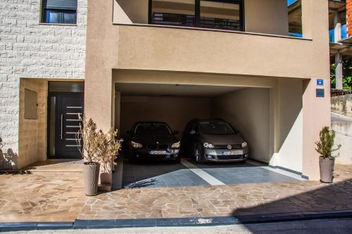 two cars are parked inside of a garage at Ralux apartman Tivat in Tivat