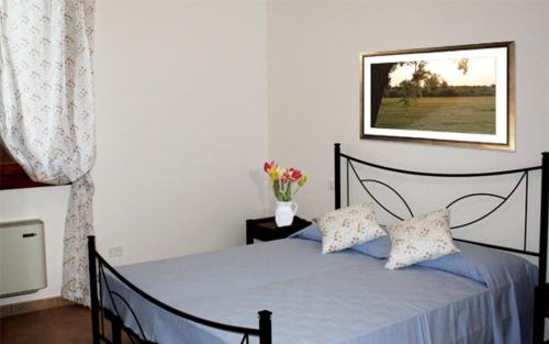 een slaapkamer met een bed met blauwe lakens en een foto aan de muur bij Agriturismo Ca' Pisani in Porto Viro