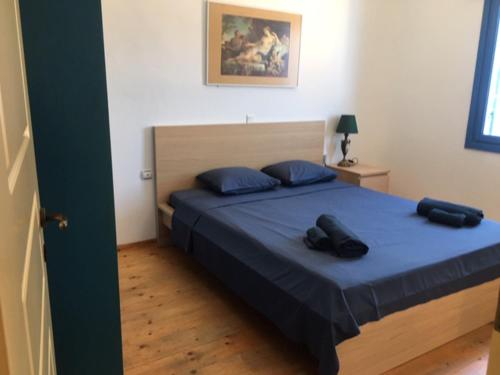 una camera da letto con un letto con due scarpe nere di Ftelia Panoramic Sea View Villa Aias a Ftelia