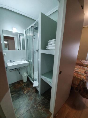 a bathroom with a sink and a toilet and a mirror at Hostal Riesco in Madrid