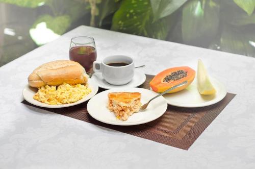 a table with two plates of food and a cup of coffee at Antico Plaza Hotel in Taubaté